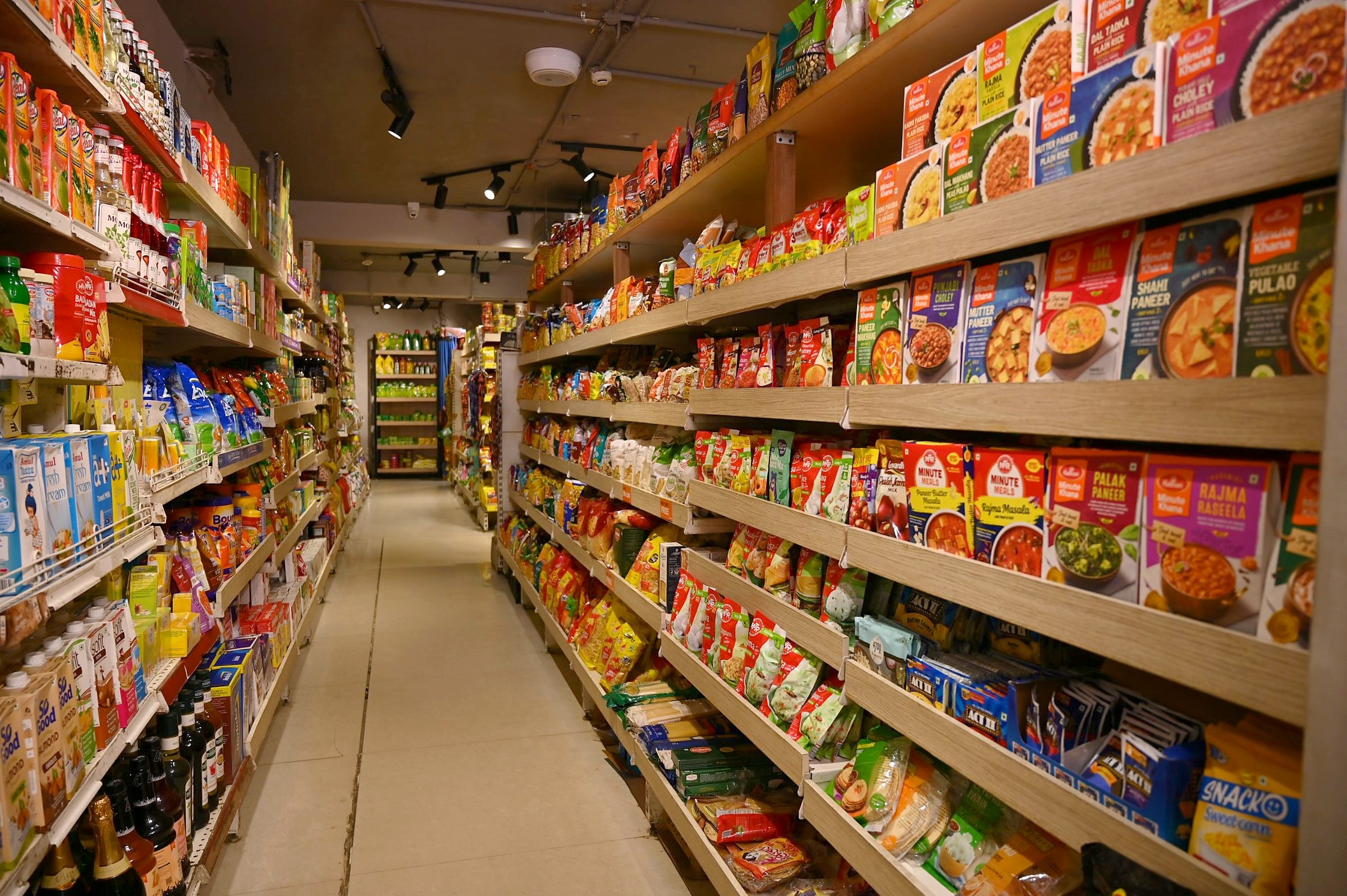 A bright, fully stocked aisle in the Any Minute store